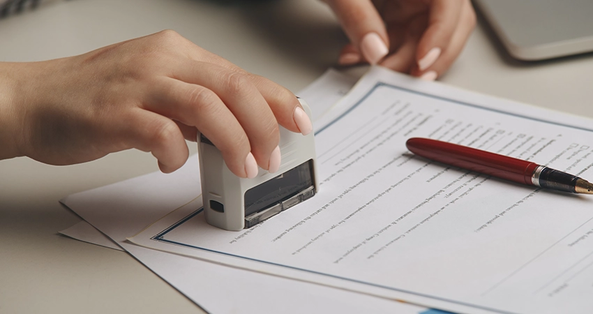 person using notary stamp on form